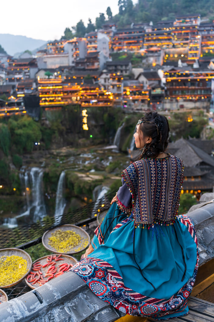 chica contemplando el atardecer en ciudad Lijiang